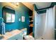Stylish bathroom featuring teal walls, walk-in shower and a unique round mirror at 332 Maple Dr, Frederick, CO 80530