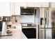 Bright kitchen with white cabinets, stainless steel appliances, and ample countertop space at 332 Maple Dr, Frederick, CO 80530