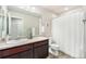 Bathroom with dark wood cabinets, tile flooring, and shower with curtain at 4755 Memphis St # 2, Denver, CO 80239