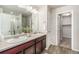 Bathroom with dual sinks, granite countertop, wood cabinets, and walk-in shower at 4755 Memphis St # 2, Denver, CO 80239