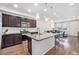 Open-concept kitchen with a large island, granite countertops, stainless steel appliances, and dark wood cabinets at 4755 Memphis St # 2, Denver, CO 80239