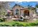 Spacious backyard patio with stone accents, outdoor seating, and lush green lawn at 5055 Mcclure Ln, Castle Rock, CO 80108