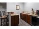 Wet bar with dark wood cabinetry, granite counters, wine fridge and seating area at 5055 Mcclure Ln, Castle Rock, CO 80108