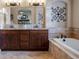 A full bathroom shows double sink vanity, large mirror and tub with tiled surround at 5055 Mcclure Ln, Castle Rock, CO 80108