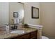 Stylish half bath with granite countertop, dark cabinets, and decorative mirror at 5055 Mcclure Ln, Castle Rock, CO 80108
