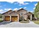 Inviting home showcasing a double wooden garage door, stone accents, and a beautifully landscaped front at 5055 Mcclure Ln, Castle Rock, CO 80108