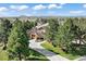 Lush front yard features mature trees, a circular driveway, and a well-maintained lawn at 5055 Mcclure Ln, Castle Rock, CO 80108