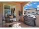 Covered patio features an outdoor table and chairs, and a modern gas grill at 5055 Mcclure Ln, Castle Rock, CO 80108