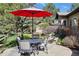 Charming patio area with a dining table, chairs, and a red umbrella, creating a delightful outdoor dining space at 5055 Mcclure Ln, Castle Rock, CO 80108