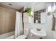 Bathroom features a shower with a white shower curtain, a decorative mirror and flora at 2240 N Clay St # 406, Denver, CO 80211