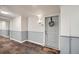 Hallway of a residence showing grey wainscotting, and a light grey door with a wreath at 2240 N Clay St # 406, Denver, CO 80211