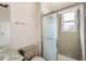 Bathroom featuring a tiled shower with glass doors and a window for natural light at 3777 S Walden St, Aurora, CO 80013