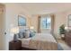 Bedroom featuring a large bed, a bedside table and lamp, and a window at 3777 S Walden St, Aurora, CO 80013