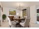 Staged dining room with a round table, stylish chairs, and elegant chandelier; ready for dinner parties at 3777 S Walden St, Aurora, CO 80013