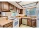 Functional kitchen featuring wood cabinets, a classic white range, and a bright window over the sink at 3777 S Walden St, Aurora, CO 80013