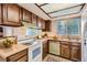 Functional kitchen with wood cabinets, white appliances, and an abundance of natural light at 3777 S Walden St, Aurora, CO 80013