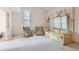 Empty living room with patterned furniture, large windows with ornate drapes, and stairway at 3777 S Walden St, Aurora, CO 80013