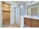 Bathroom featuring a shower with glass door and single sink vanity adjacent to a closet at 6079 W Prentice Ave, Littleton, CO 80123