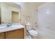 Cozy bathroom with white tiled shower over tub, single sink vanity, and a toilet at 6079 W Prentice Ave, Littleton, CO 80123