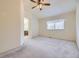 Light-filled bedroom with neutral carpet, ceiling fan, and archway leading to an en-suite bathroom at 6079 W Prentice Ave, Littleton, CO 80123