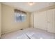 Bedroom with a large window, carpet flooring, a closet with sliding doors, and neutral walls at 6079 W Prentice Ave, Littleton, CO 80123