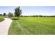 Beautiful expansive green space for outdoor activities and relaxation; features mature trees and paved walkway at 6079 W Prentice Ave, Littleton, CO 80123