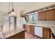 Kitchen with wood cabinets, center island, laminate wood flooring, white appliances, and sliding glass door to deck at 6079 W Prentice Ave, Littleton, CO 80123