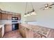 Kitchen featuring wood cabinets, center island with seating, black appliances, and eat-in area at 6079 W Prentice Ave, Littleton, CO 80123