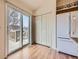 Kitchen with wood cabinets, a sliding glass door to deck, laminate wood flooring, and white refrigerator at 6079 W Prentice Ave, Littleton, CO 80123