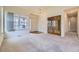 Bright living room with large windows, neutral carpet, and glass paneled double doors at 6079 W Prentice Ave, Littleton, CO 80123