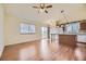 Inviting living room with wood floors opens to kitchen island with pendant lighting and adjacent sliding glass door at 6079 W Prentice Ave, Littleton, CO 80123