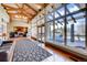 Grand lobby space featuring high ceilings, exposed beams, hardwood floors, fireplace, and lake views at 6079 W Prentice Ave, Littleton, CO 80123
