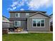 Landscaped backyard with patio furniture, lush lawn, and a two-story house at 821 Boulder Peak Ave, Erie, CO 80516