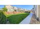 Large grassy backyard with a wood fence and a concrete walkway at 821 Boulder Peak Ave, Erie, CO 80516