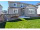 Backyard featuring a well-maintained lawn, patio, and gray siding on home exterior at 821 Boulder Peak Ave, Erie, CO 80516