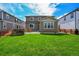 Expansive backyard with lush green grass and a patio, framed by neighboring homes and a stone feature at 821 Boulder Peak Ave, Erie, CO 80516