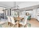 Elegant dining room with a modern light fixture and views into a bright kitchen and living space at 821 Boulder Peak Ave, Erie, CO 80516