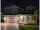 Charming two-story home with a well-manicured lawn and a two-car garage, beautifully lit at night at 821 Boulder Peak Ave, Erie, CO 80516