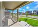 Covered front porch offering a view of the lush, green lawn and tree-lined neighborhood street at 821 Boulder Peak Ave, Erie, CO 80516