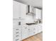 White kitchen boasts modern appliances, a gas range, sleek backsplash, and ample cabinet space at 821 Boulder Peak Ave, Erie, CO 80516