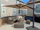 Cozy outdoor patio area with comfortable seating, a fire pit, and an umbrella for shade at 821 Boulder Peak Ave, Erie, CO 80516