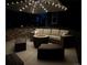 Inviting outdoor patio at night with comfortable seating and a fire pit under a lighted umbrella at 821 Boulder Peak Ave, Erie, CO 80516