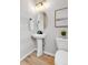 Clean and modern powder room with a pedestal sink, oval mirror, and neutral decor at 821 Boulder Peak Ave, Erie, CO 80516