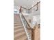 Staircase featuring carpeted steps, dark metal railing, and light walls and trim in a modern home at 821 Boulder Peak Ave, Erie, CO 80516