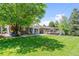 Spacious backyard with a deck, patio, and mature trees at 2520 Eldridge Cir, Golden, CO 80401