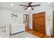 Bright bedroom with wood floors, ceiling fan, closet and changing table at 2520 Eldridge Cir, Golden, CO 80401
