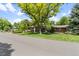 Charming brick home featuring mature trees, lush lawn, and lovely landscaping at 2520 Eldridge Cir, Golden, CO 80401