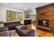 Comfortable living room with a stone fireplace, large windows, and hardwood floors creating a cozy and inviting atmosphere at 2520 Eldridge Cir, Golden, CO 80401