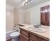 Bathroom featuring a single sink, large mirror, toilet, and bathtub with shower, and a wooden door at 916 W Alder St, Louisville, CO 80027