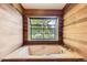 Bathtub in a wood paneled bathroom with a large window and view of the outdoors at 916 W Alder St, Louisville, CO 80027